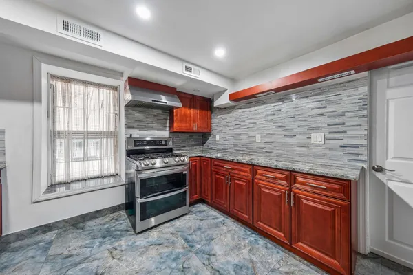 a kitchen with stainless steel appliances granite countertop a stove sink and cabinets