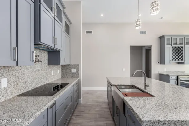 a kitchen with stainless steel appliances granite countertop a sink stove and refrigerator