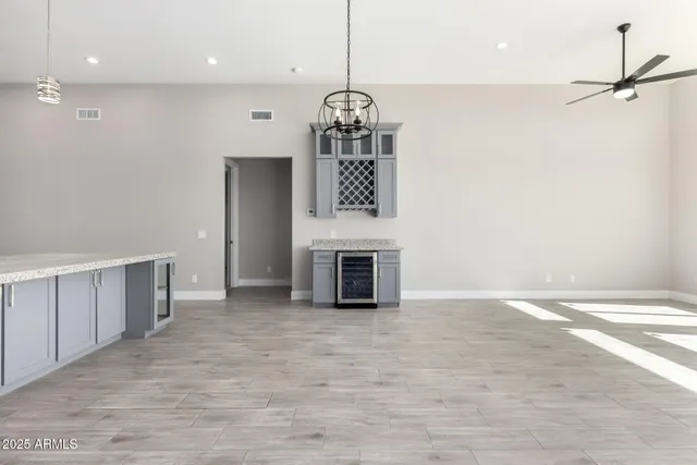 a view of a livingroom with a fireplace a chandelier and wooden floor
