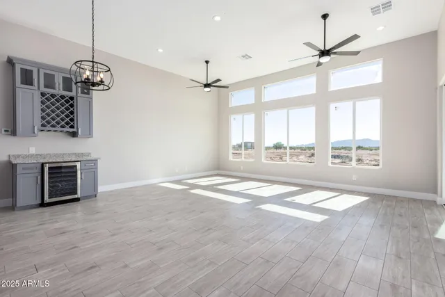 a view of an empty room with a window and kitchen view