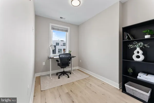 a view of a workspace with furniture and a window