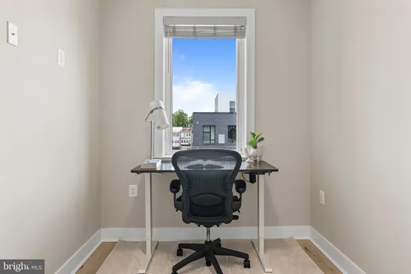 a view of a room with a door and wooden floor