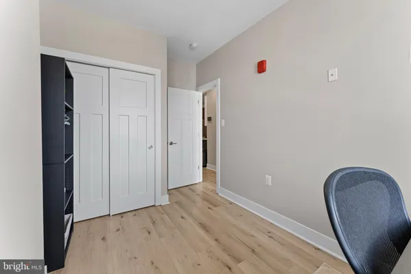 a view of a hallway with wooden floor and closet