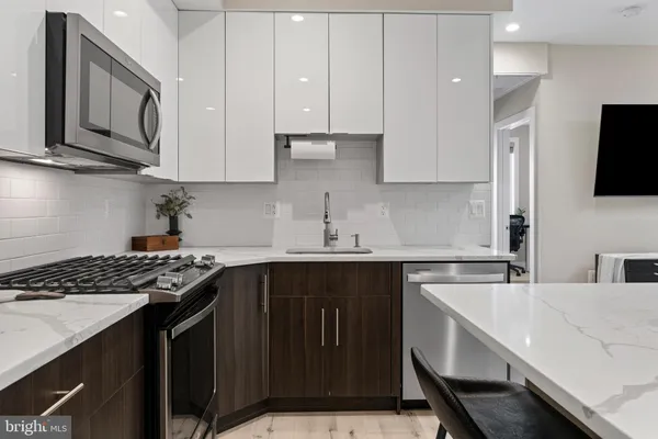 a kitchen with a sink cabinets and wooden floor