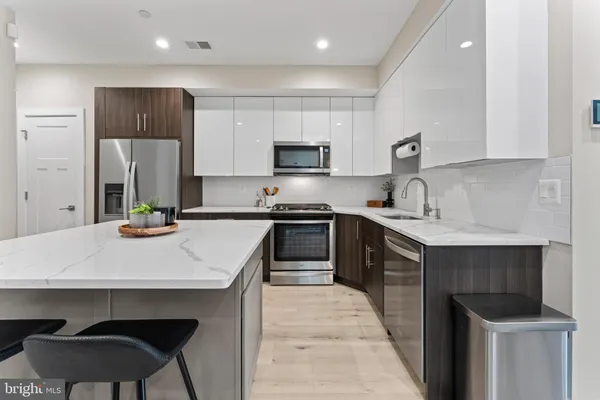 a kitchen with stainless steel appliances a stove a sink a microwave and cabinets