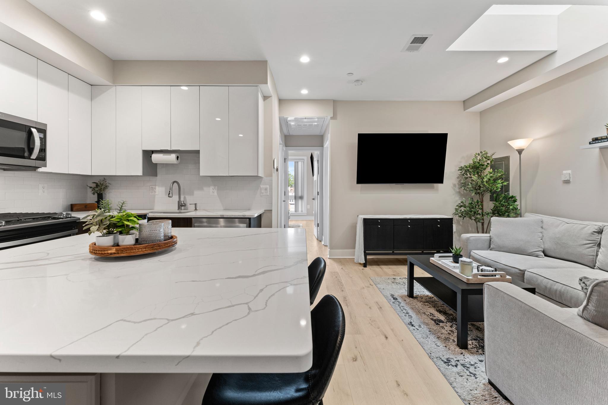 818 Kennedy Street Northwest, Unit 9 Washington, DC 20011 - Photo 8 of 23 a living room with furniture a flat screen tv and a fireplace
