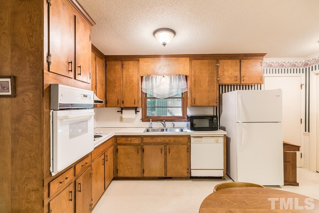 6913 Electra Drive Raleigh, NC 27607 - Photo 14 of 30 a kitchen with a stove a refrigerator and a sink
