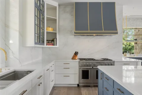a kitchen with stainless steel appliances granite countertop a sink stove and cabinets