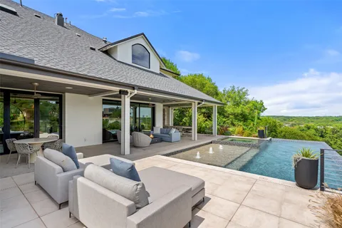 a view of a patio with couches and table and chairs with wooden fence