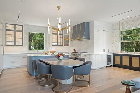 a kitchen with a dining table chairs sink and cabinets