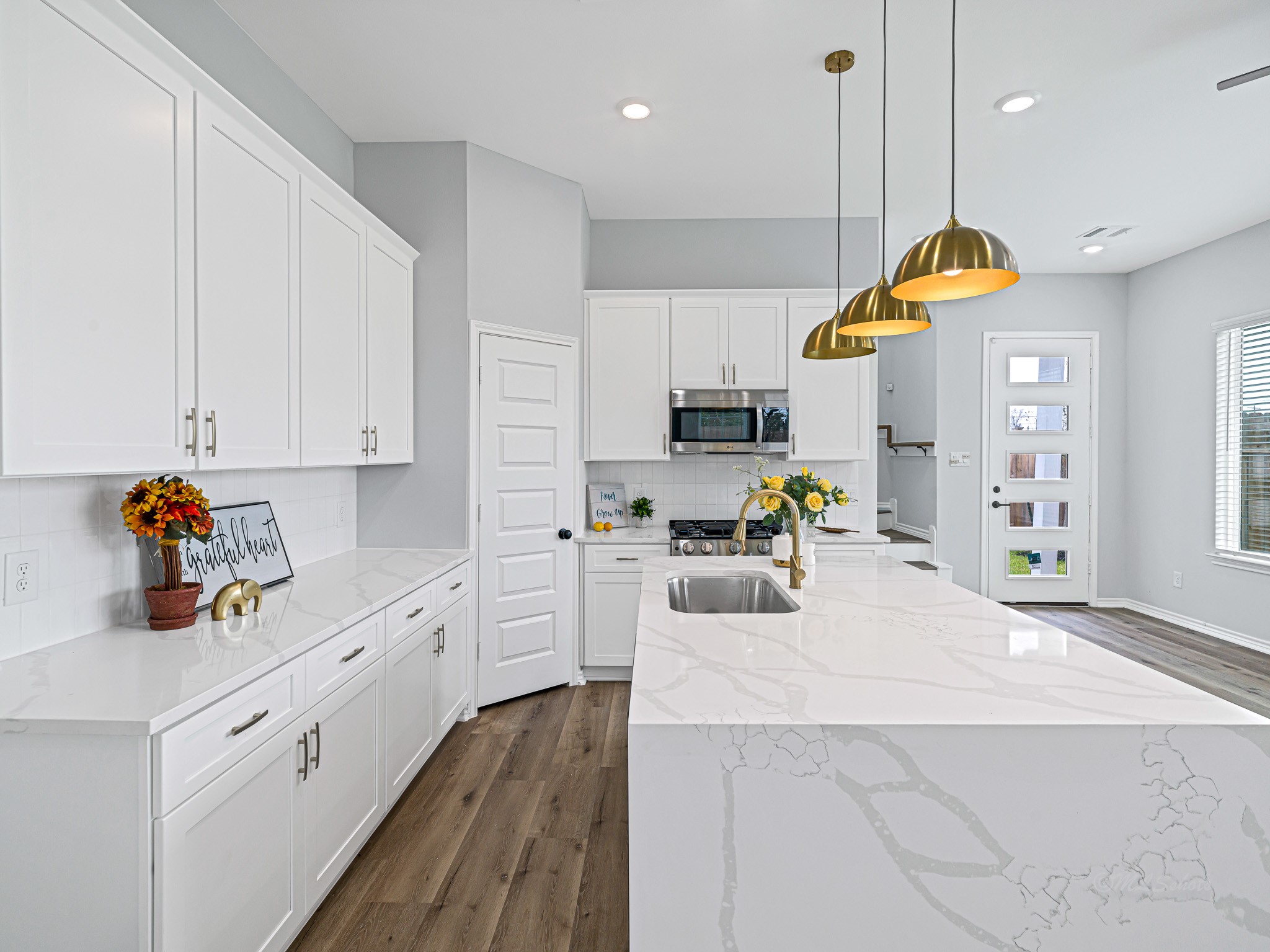 2720 Spence Street Houston, TX 77093 - Photo 11 of 30 a kitchen with kitchen island sink stove and white cabinets