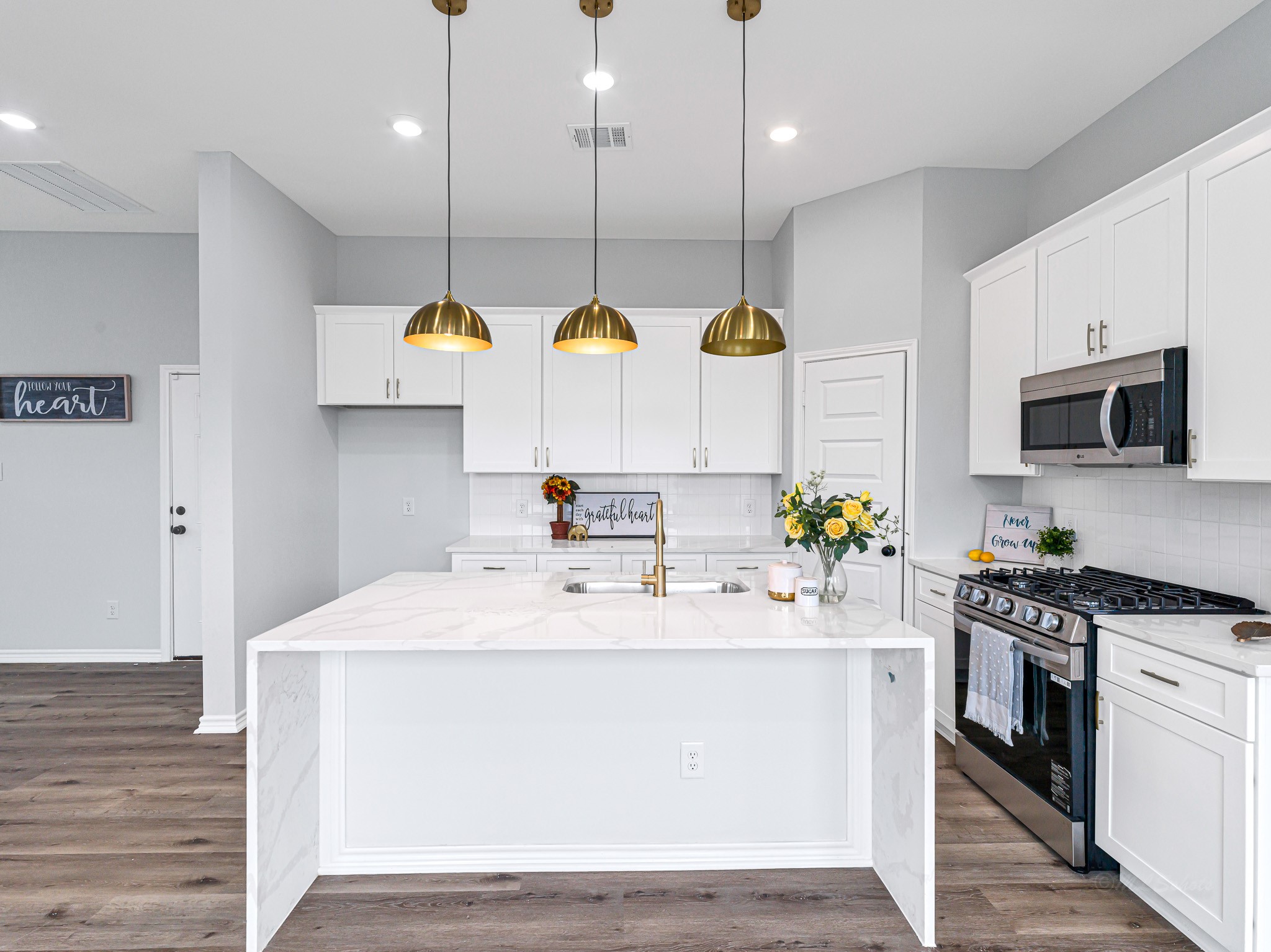 2720 Spence Street Houston, TX 77093 - Photo 12 of 30 a kitchen with kitchen island a sink stainless steel appliances and wooden floor