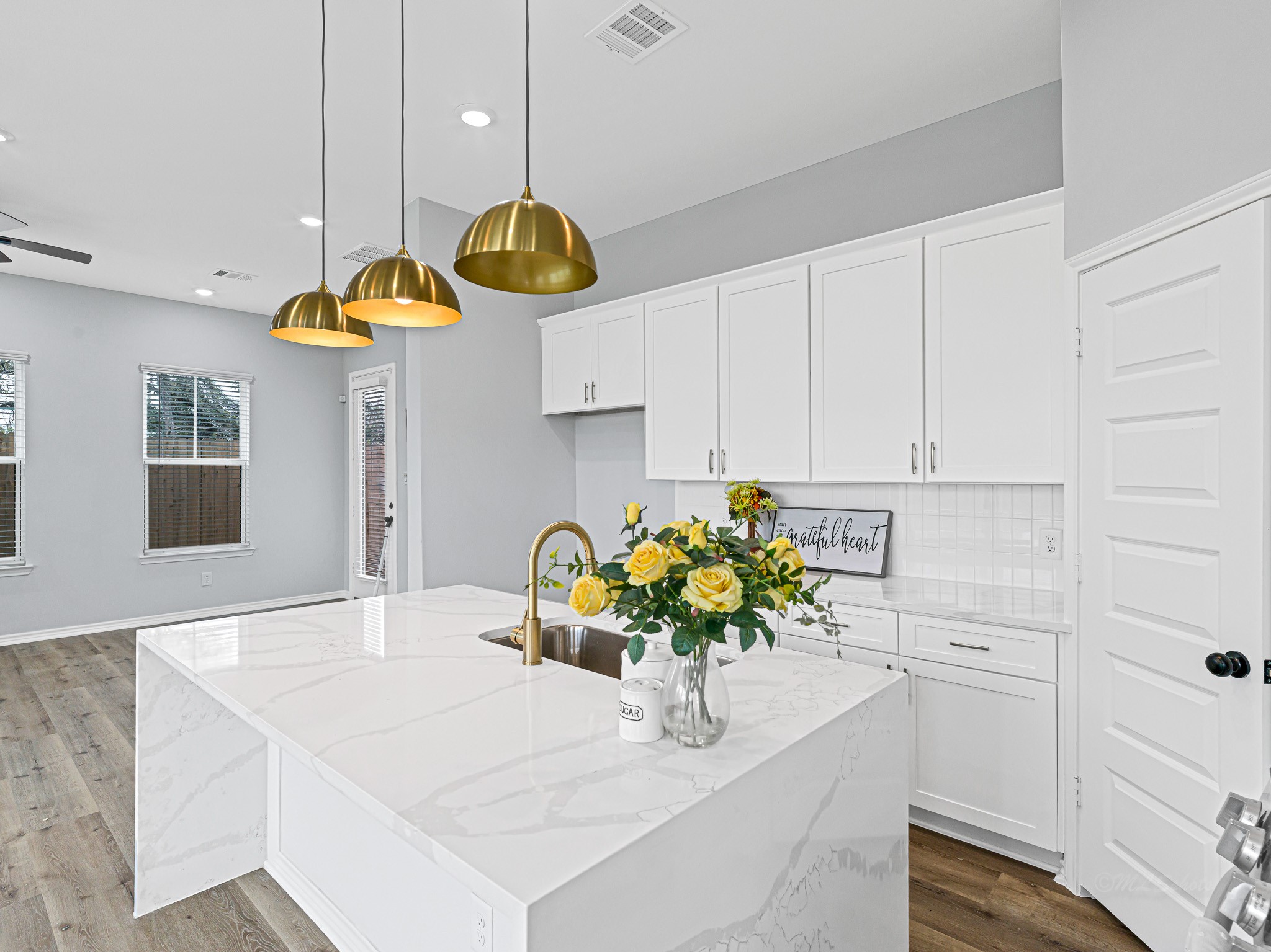 2720 Spence Street Houston, TX 77093 - Photo 13 of 30 a kitchen with a white center island a chandelier and living room view