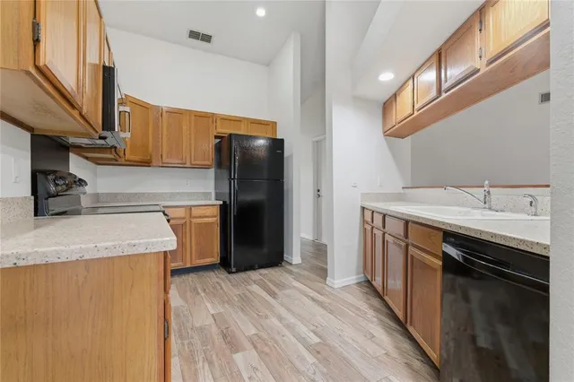 an empty room with wooden floor chandelier fan and closet area