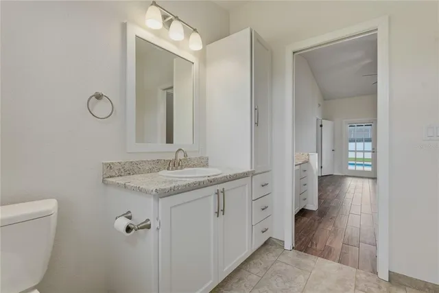 an empty room with wooden floor ceiling fan and windows