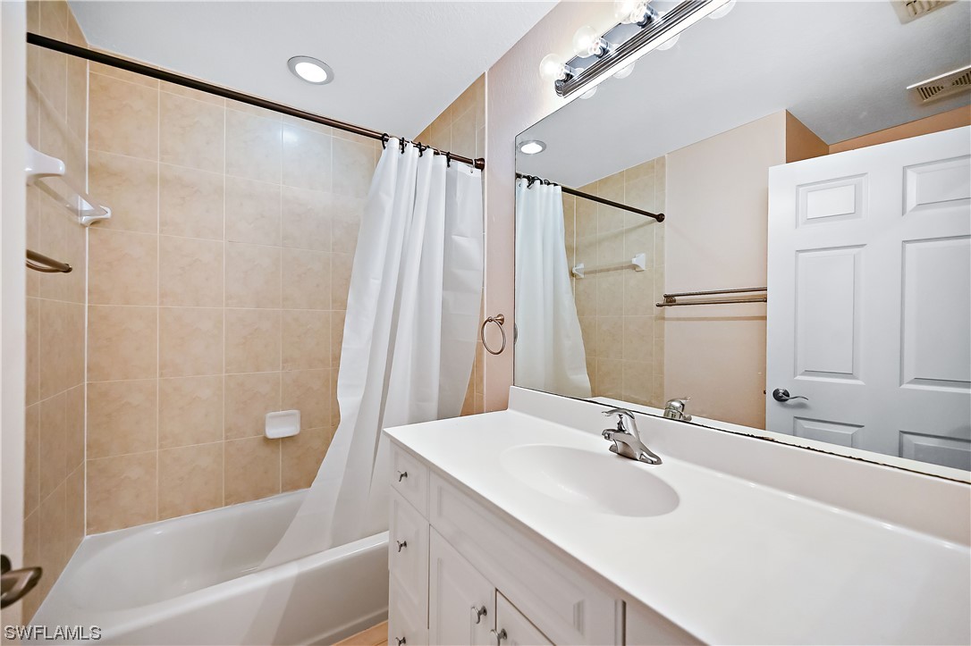 3535 18th Avenue Southeast Naples, FL 34117 - Photo 15 of 32 a bathroom with a sink mirror and a bathtub