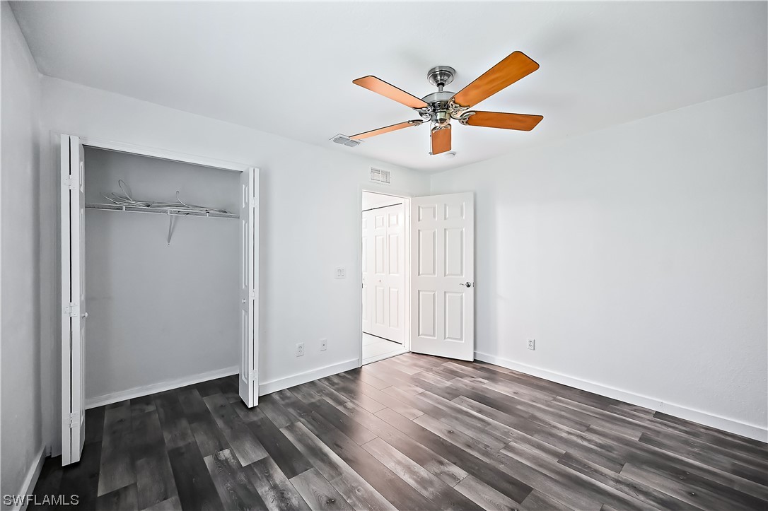 3535 18th Avenue Southeast Naples, FL 34117 - Photo 16 of 32 an empty room with wooden floor closet and fan
