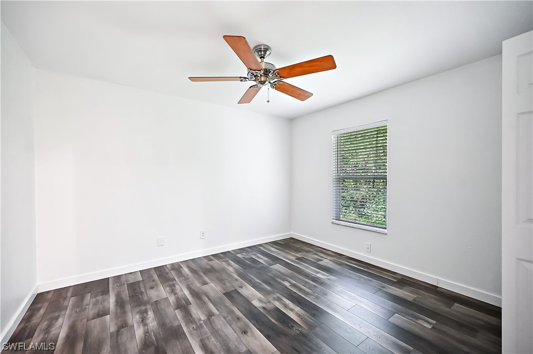3535 18th Avenue Southeast Naples, FL 34117 - Photo 17 of 32 an empty room with wooden floor ceiling fan and windows