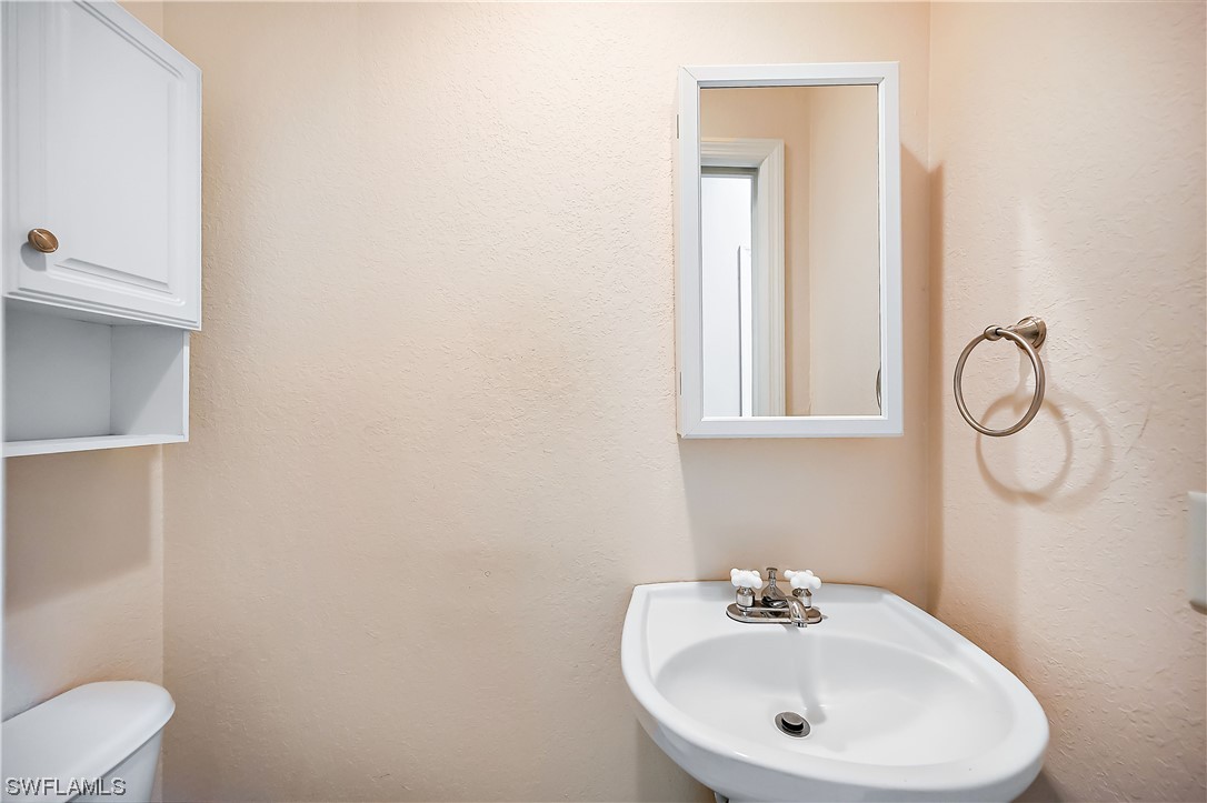 3535 18th Avenue Southeast Naples, FL 34117 - Photo 18 of 32 a bathroom with a sink a toilet and mirror