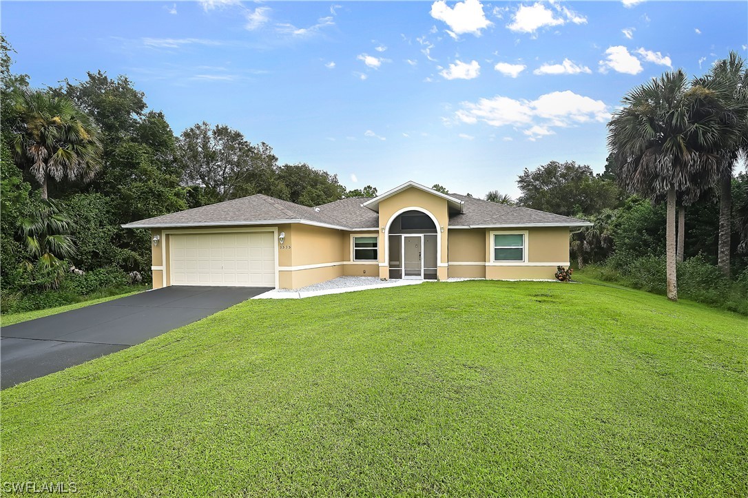 3535 18th Avenue Southeast Naples, FL 34117 - Photo 2 of 32 a view of a yard in front of a house with plants and large tree