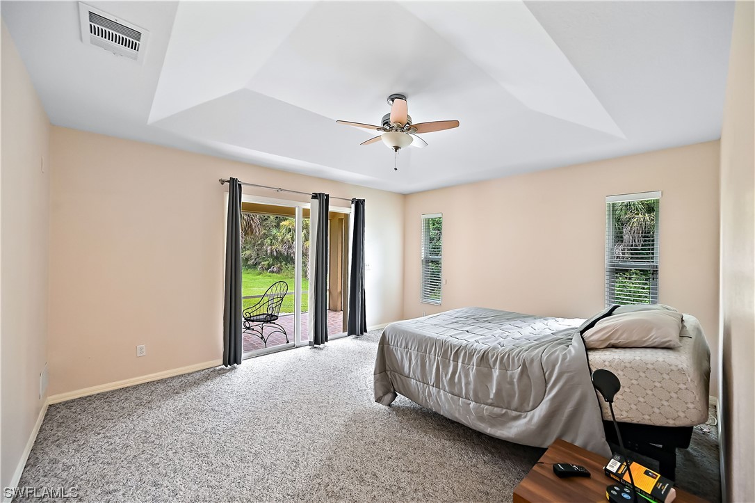 3535 18th Avenue Southeast Naples, FL 34117 - Photo 21 of 32 a bedroom with a bed and a chandelier