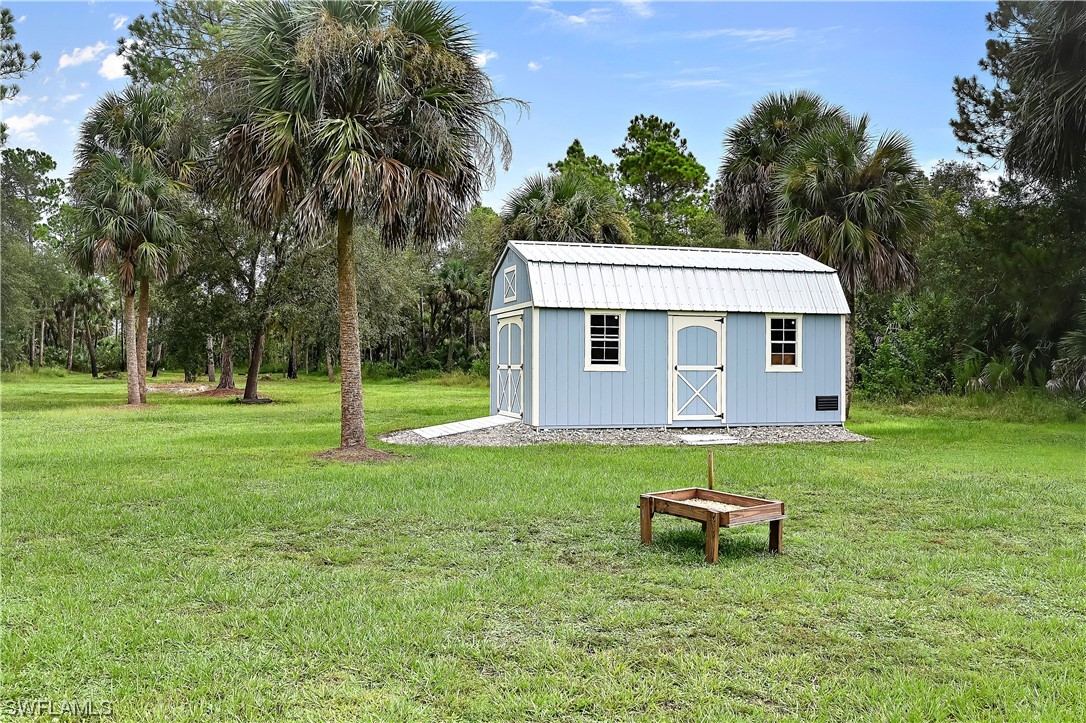 3535 18th Avenue Southeast Naples, FL 34117 - Photo 29 of 32 a view of a house with a backyard and a tree