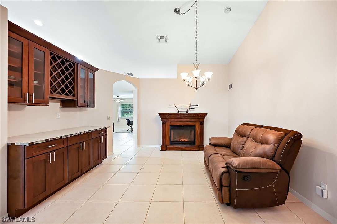 3535 18th Avenue Southeast Naples, FL 34117 - Photo 5 of 32 a living room with furniture a fireplace and a chandelier
