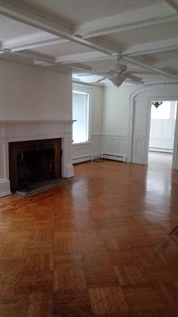 a view of empty room with wooden floor and fireplace