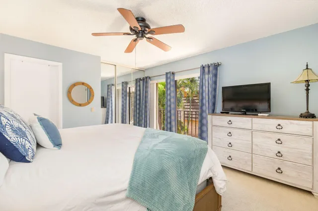 a bedroom with a large bed and flat tv screen on dresser