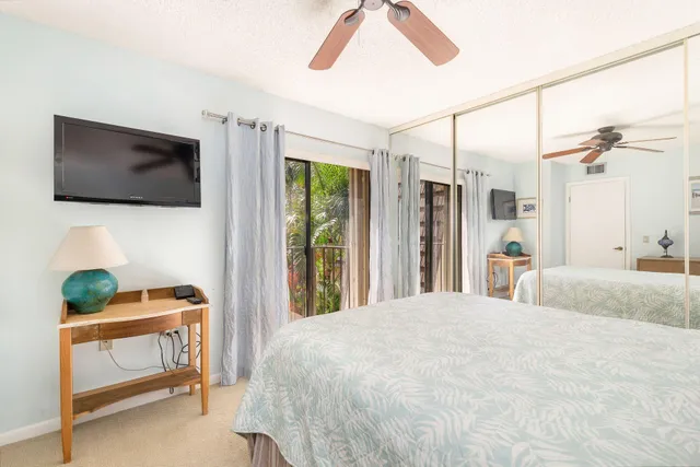 a bedroom with a bed a flat screen tv and a window