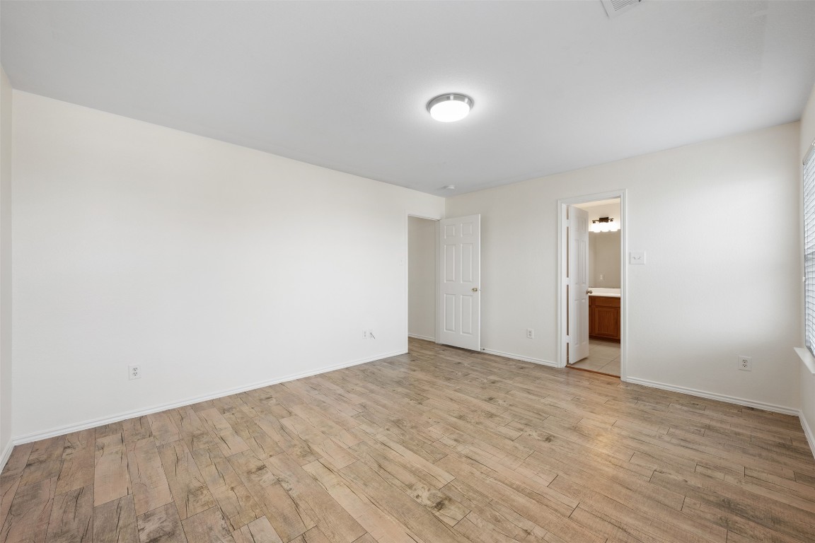 15216 Mandarin Crossing Pflugerville, TX 78660 - Photo 27 of 40 Unfurnished bedroom with light wood-style flooring and ensuite bath