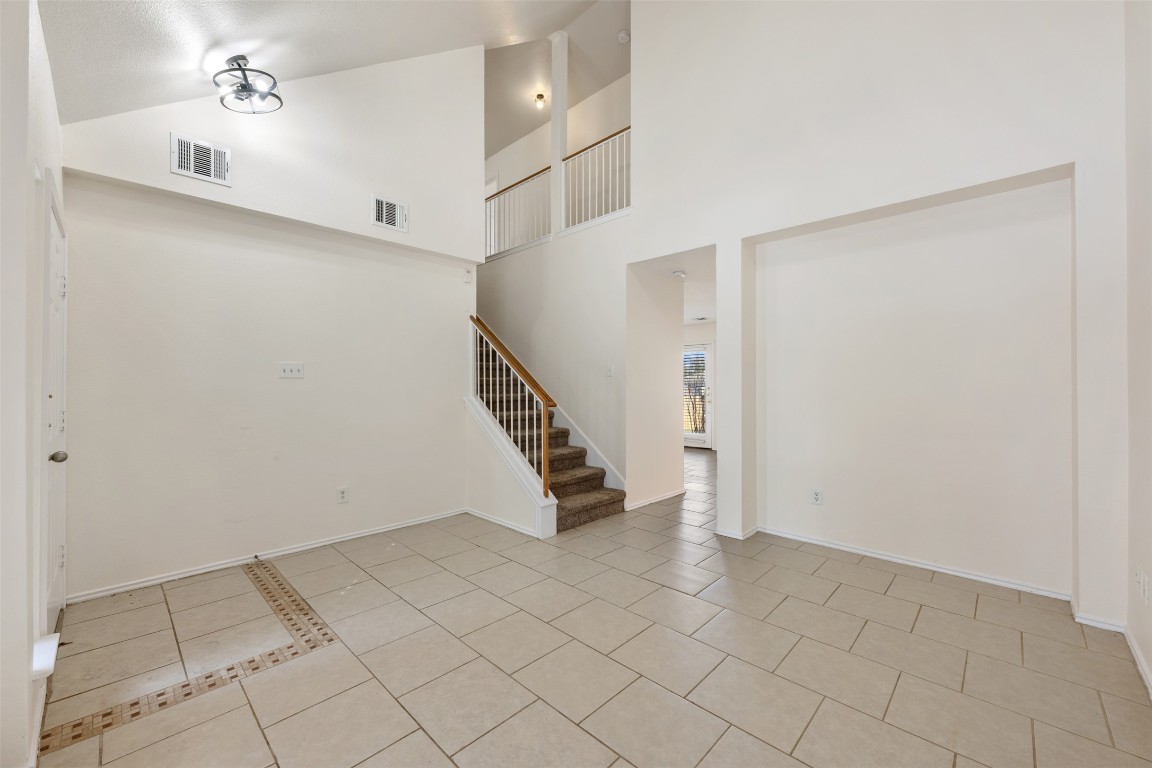 15216 Mandarin Crossing Pflugerville, TX 78660 - Photo 7 of 40 Foyer with high vaulted ceiling, light tile patterned floors, and stairway