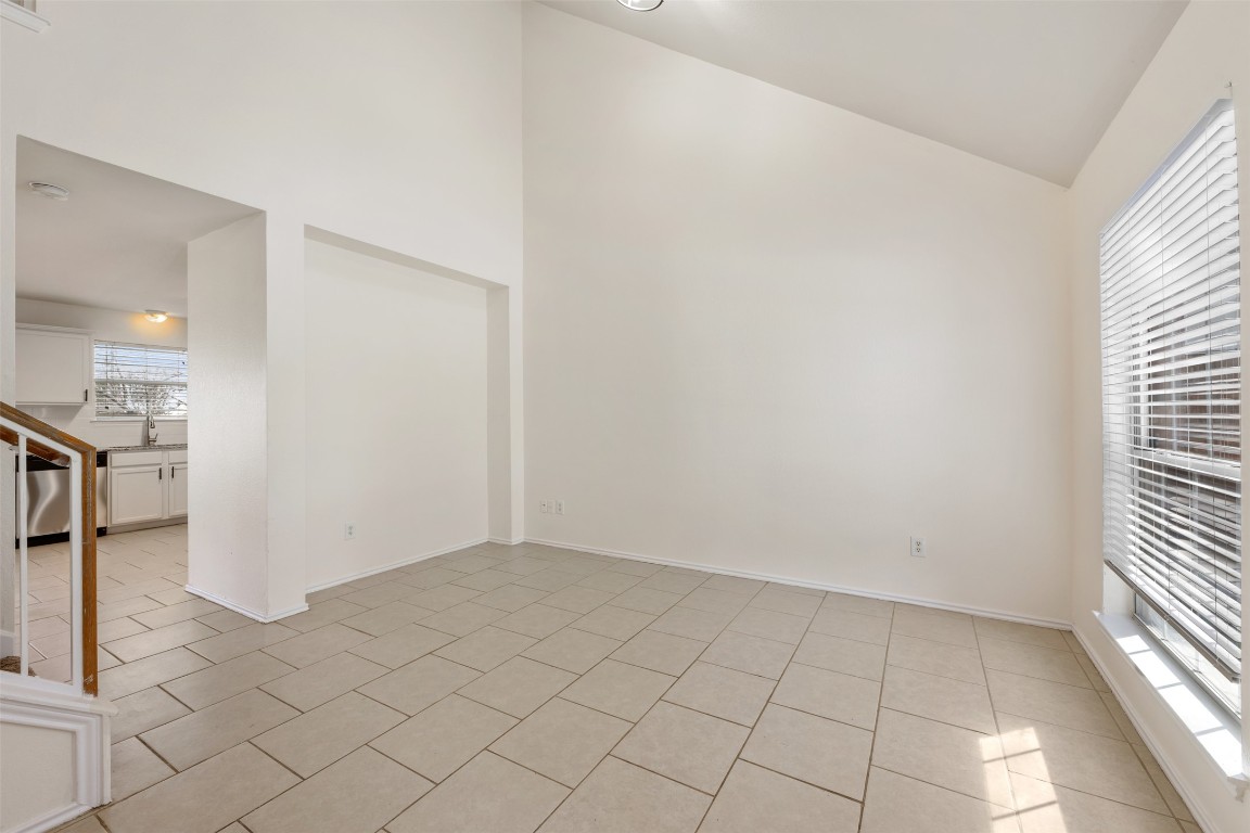 15216 Mandarin Crossing Pflugerville, TX 78660 - Photo 8 of 40 Empty room with high vaulted ceiling and light tile patterned floors