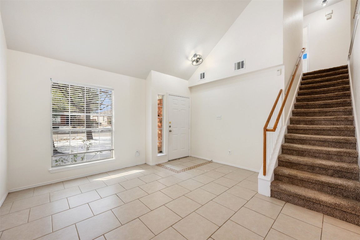 15216 Mandarin Crossing Pflugerville, TX 78660 - Photo 9 of 40 Foyer entrance featuring light tile patterned floors, stairs, and high vaulted ceiling