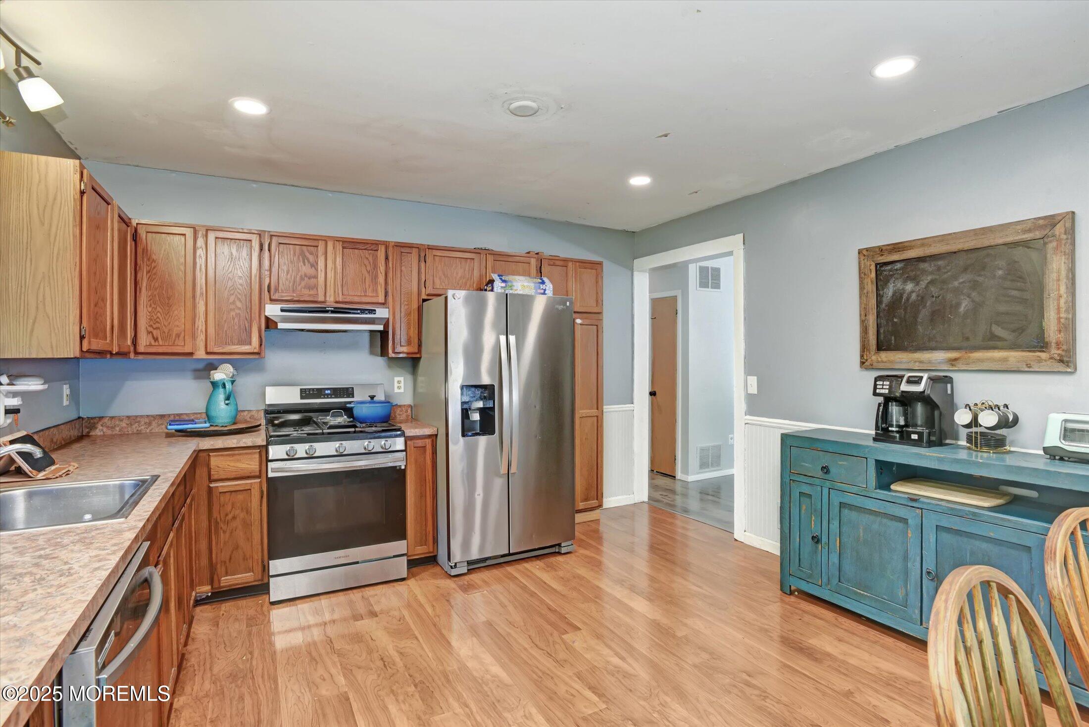 10 Bowman Road Jackson, NJ 08527 - Photo 11 of 32 a kitchen with stainless steel appliances granite countertop a refrigerator a sink dishwasher a stove with wooden cabinets and floor