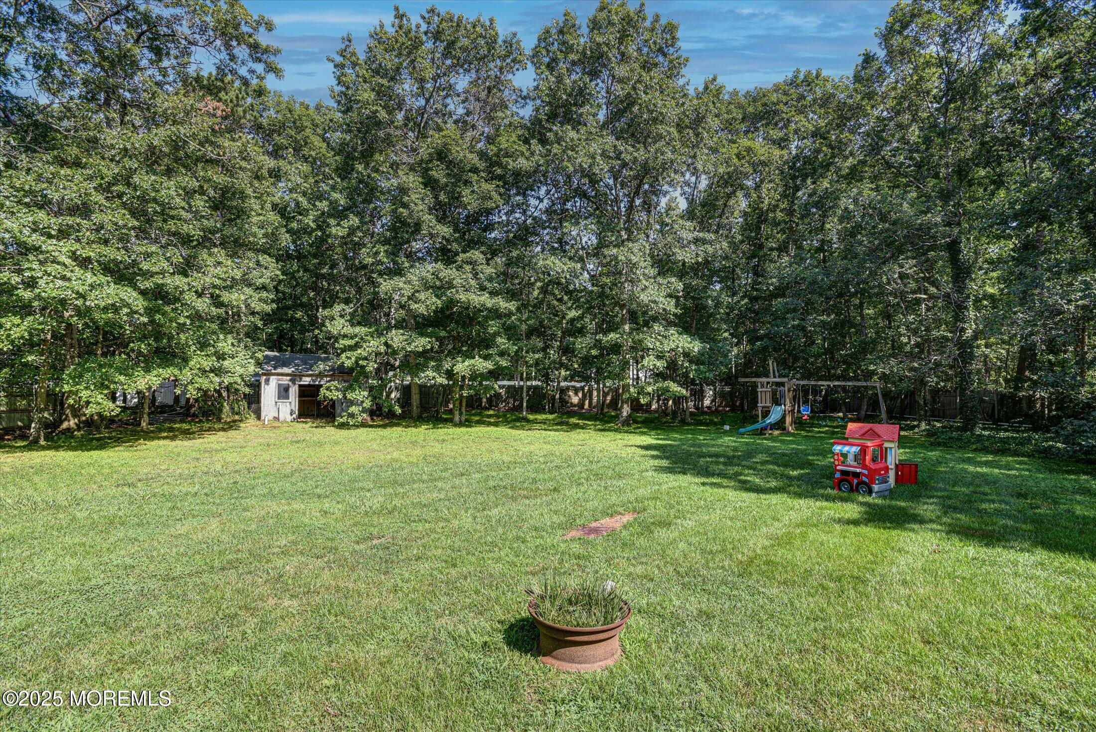10 Bowman Road Jackson, NJ 08527 - Photo 30 of 32 a view of a backyard with table and chairs and large trees