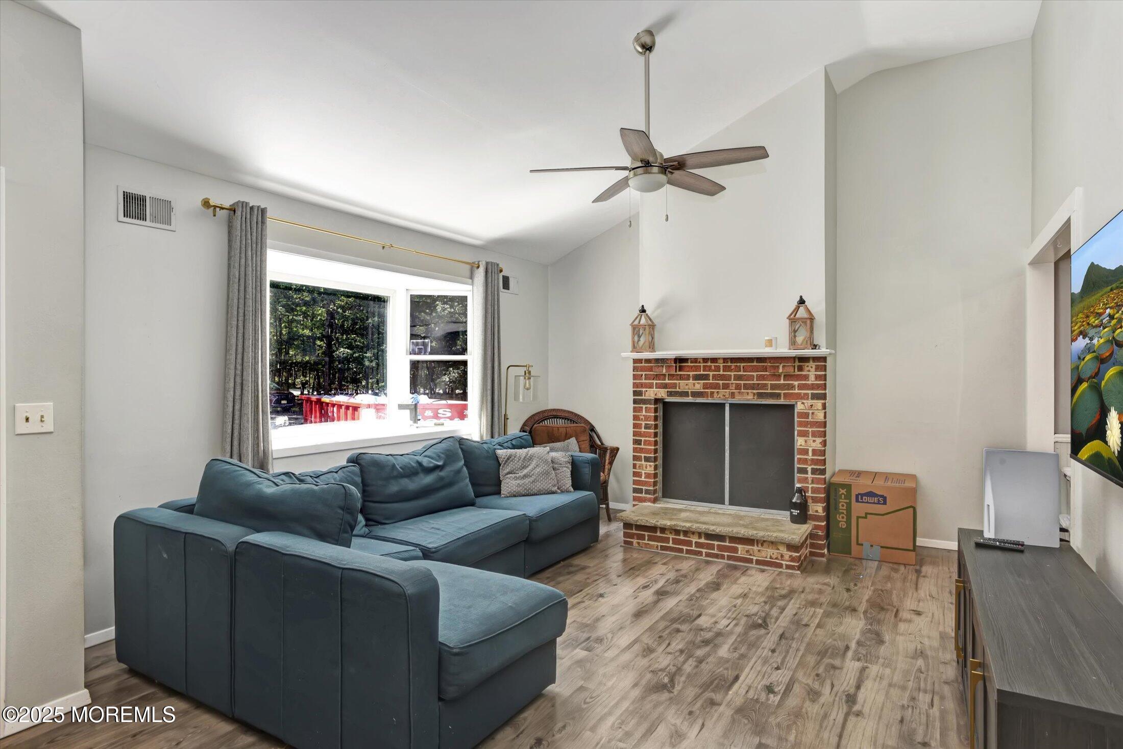 10 Bowman Road Jackson, NJ 08527 - Photo 4 of 32 a living room with furniture a fireplace and a flat screen tv