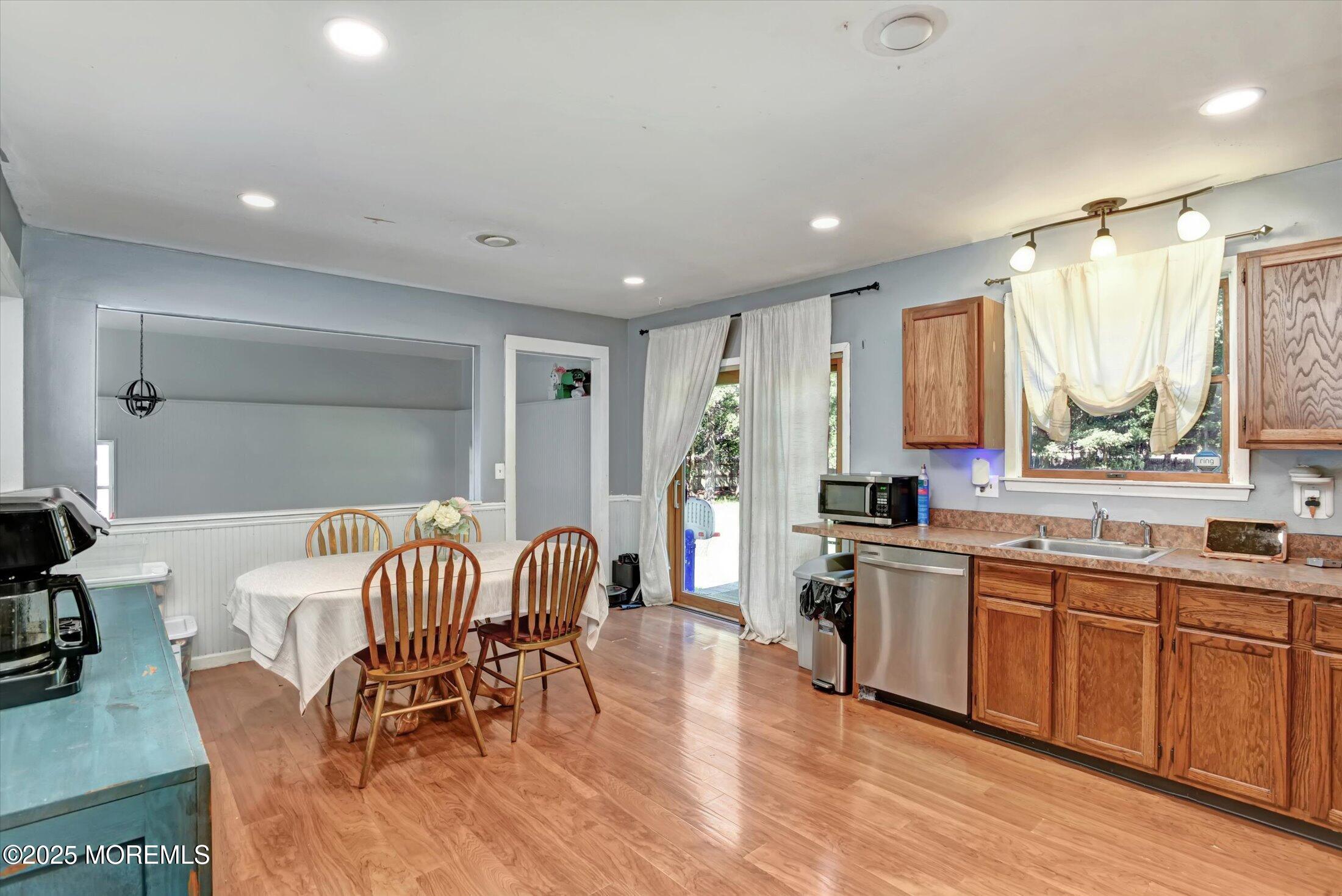 10 Bowman Road Jackson, NJ 08527 - Photo 7 of 32 a kitchen with stainless steel appliances granite countertop a stove top oven a sink dishwasher a dining table and chairs with wooden floor