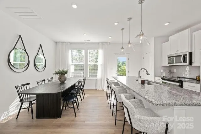 a dining room with kitchen island a chandelier dining table and chairs