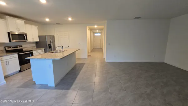 a large kitchen with a large counter top stainless steel appliances and cabinets