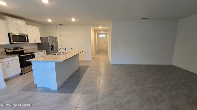 a large kitchen with a large counter top stainless steel appliances and cabinets