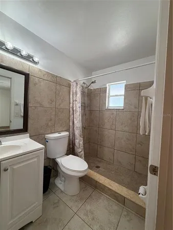 a bathroom with a shower a toilet and sink