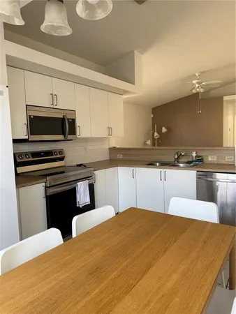 a kitchen with stainless steel appliances a stove a sink a microwave and cabinets