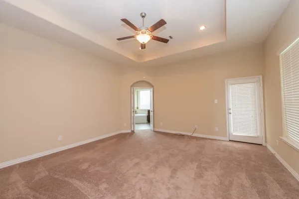 an empty room with closet and ceiling fan