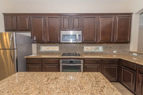 a kitchen with stainless steel appliances granite countertop wooden cabinets a sink and a stove