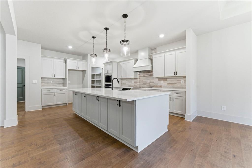 158 Races Road Hoschton, GA 30548 - Photo 11 of 24 a large white kitchen with kitchen island a sink a stove and a refrigerator
