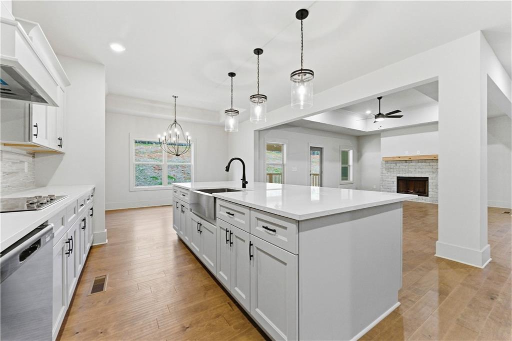 158 Races Road Hoschton, GA 30548 - Photo 13 of 24 a large kitchen with kitchen island a stove a sink a center island and a wooden floor