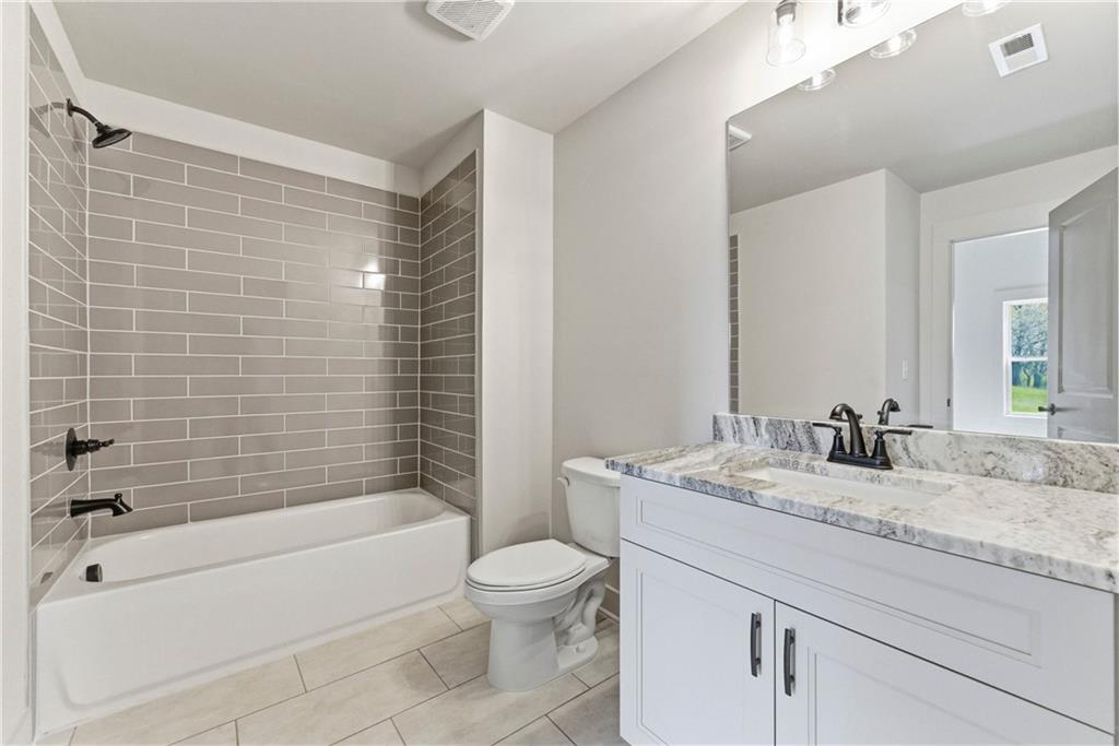 158 Races Road Hoschton, GA 30548 - Photo 20 of 24 a bathroom with a granite countertop bathtub sink vanity mirror and toilet