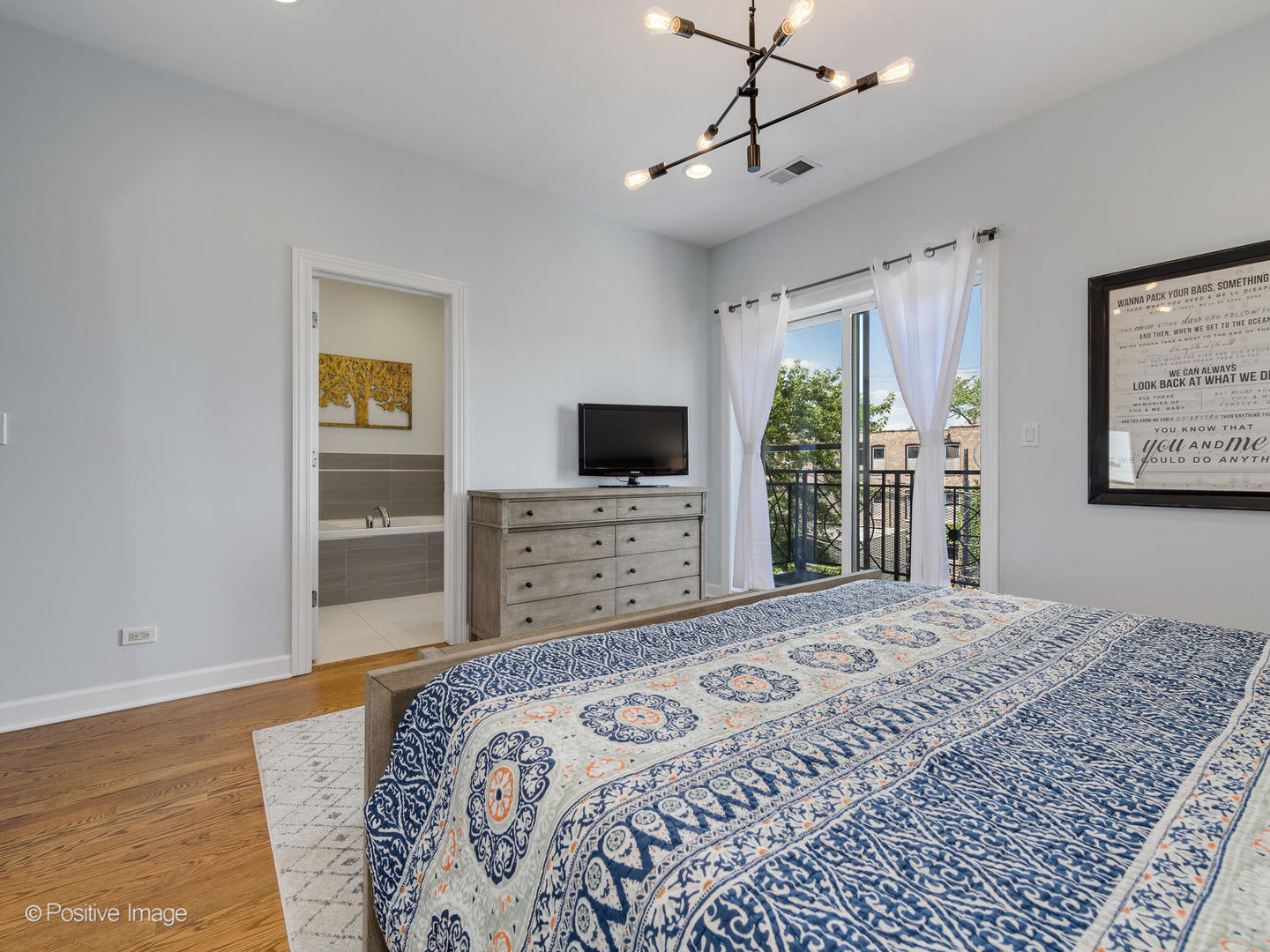 2128 West Rice Street, Unit 3 Chicago, IL 60622 - Photo 17 of 23 a bedroom with a bed and a flat screen tv