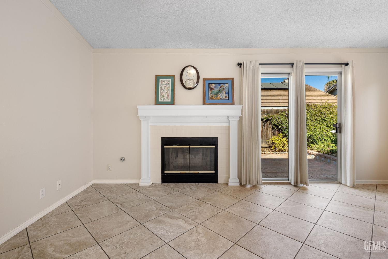 Undisclosed Address Bakersfield, CA 93312 - Photo 11 of 40 a view of an empty room with a fireplace and a window